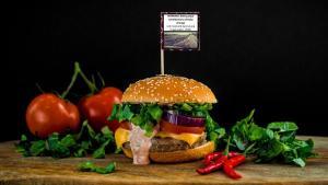 Una hamburguesa con una etiqueta en la que se advierte sobre el impacto de la carne en el medio ambiente.