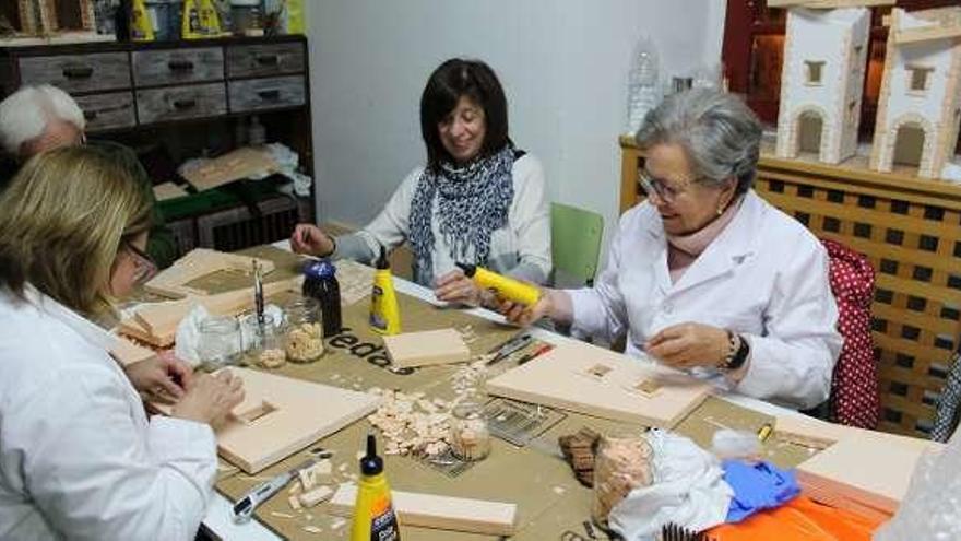 Ángeles Martínez, Francisco Sanjurjo, Marta Magadán y Lely García trabajando en sus maquetas.