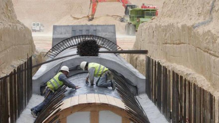 Una pareja de operarios trabaja en una de las canalizaciones del post-trasvase Júcar-Vinalopó por donde se distribuirá el agua que llegue de Cullera.