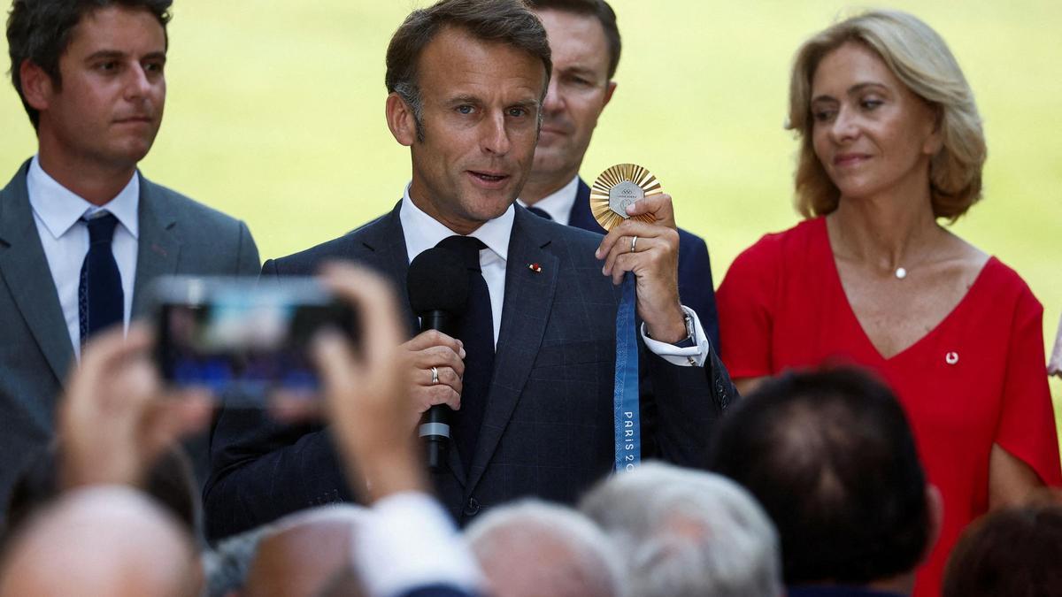 Macron muestra una medalla en Paris.