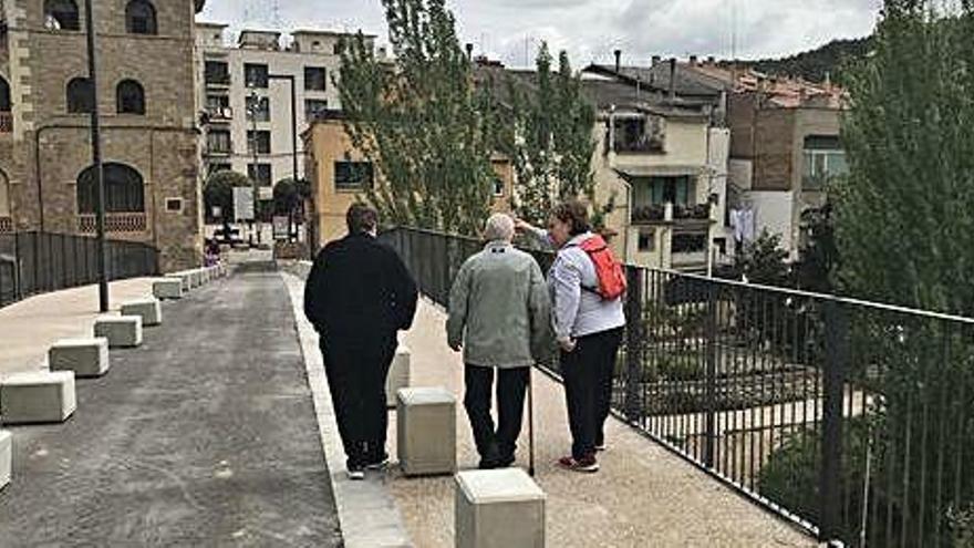 Vianants travessant a peu el pont vell de Sallent, ahir al migdia