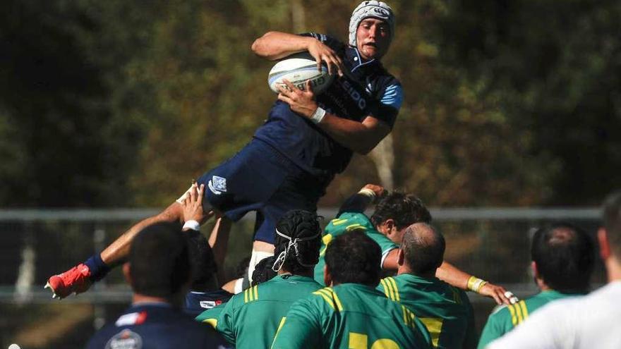 Javier Abadía captura el oval en una touch en un partido en As Lagoas. // R. Grobas