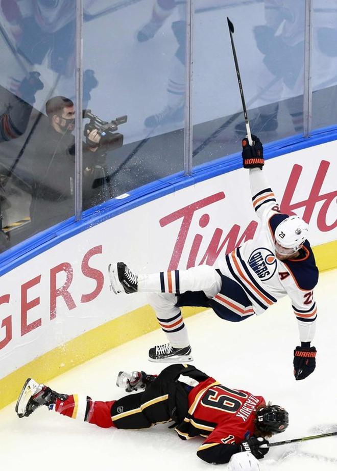 Leon Draisaitl # 29 de los Edmonton Oilers choca con Matthew Tkachuk # 19 de Calgary Flames durante el primer período en un juego de exhibición previo a los playoffs de la NHL Stanley Cup 2020 en Rogers Place.