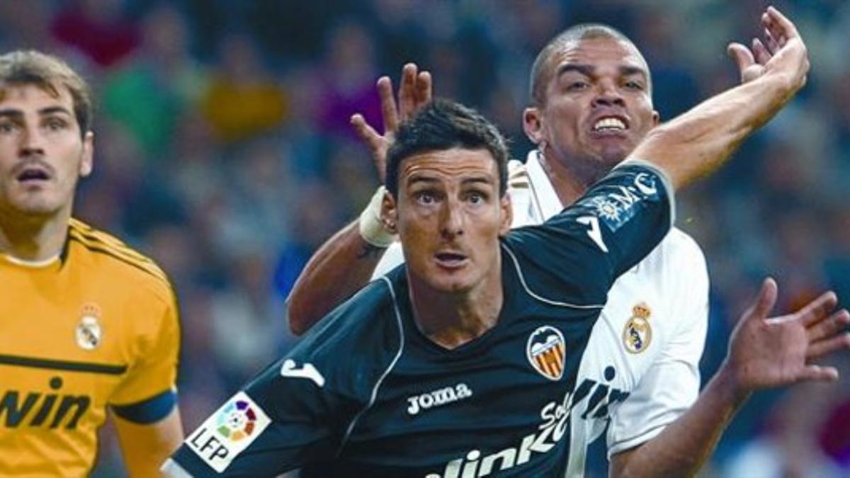 El valencianista Aduriz lucha con Pepe ante la mirada de Casillas, ayer.
