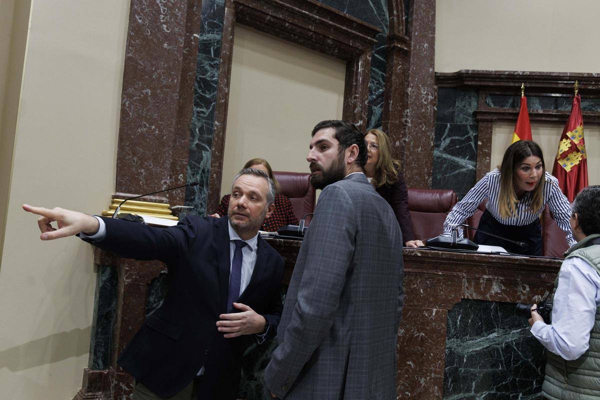 El portavoz del Grupo Popular, Joaquín Segado, indica a Antelo su nuevo asiento en el Pleno tras haber sido expulsado del Grupo Vox.