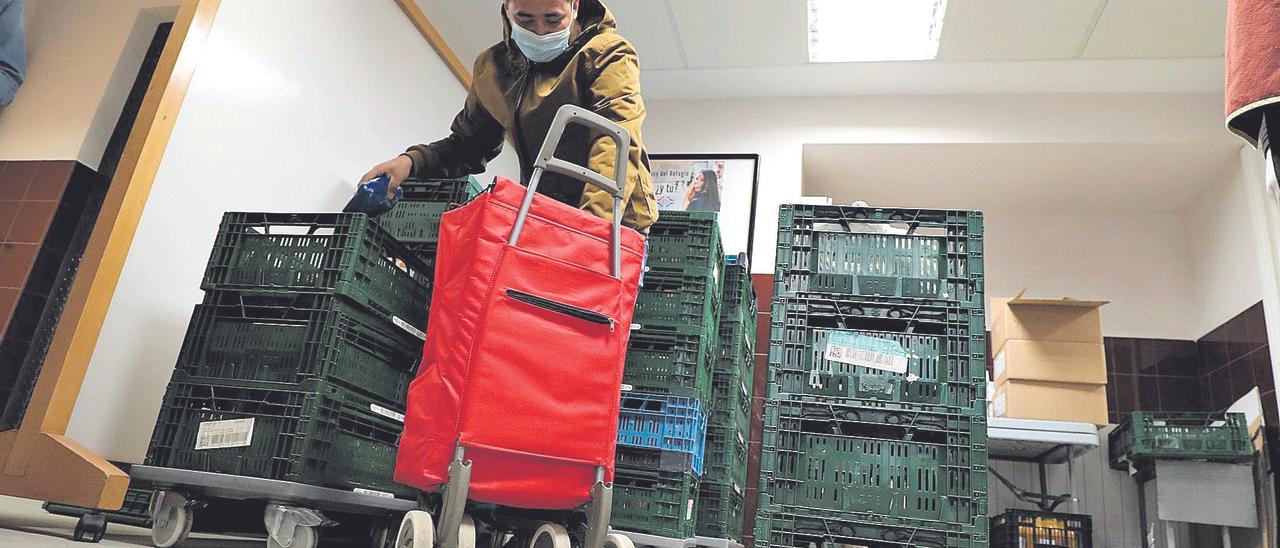 El ingreso mínimo nació con el objetivo de rescatar a las familias que peor lo han pasado por el covid. En la imagen, un hombre coge alimentos de una ONG.