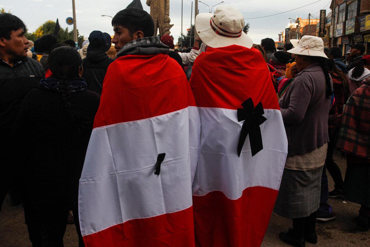 Familiares de las 18 personas muertas en los enfrentamientos en Perú esperan junto a los ataúdes vacíos la entrega de los cuerpos ante la morgue del Hospital Carlos Monge Medrano, en Juliaca (Perú).