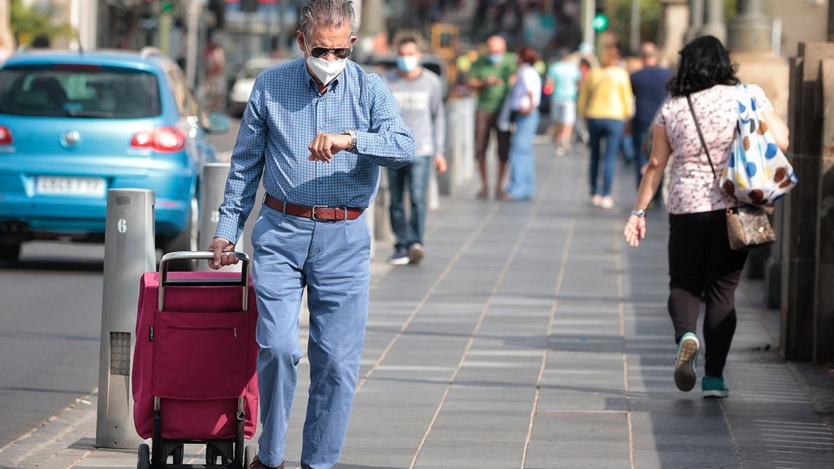 Un hombre con mascarilla camina por Santa Cruz de Tenerife