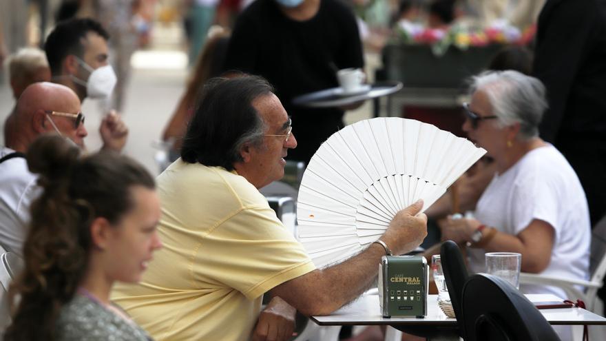 Varias personas intentan protegerse del calor en el día en foto de archivo.