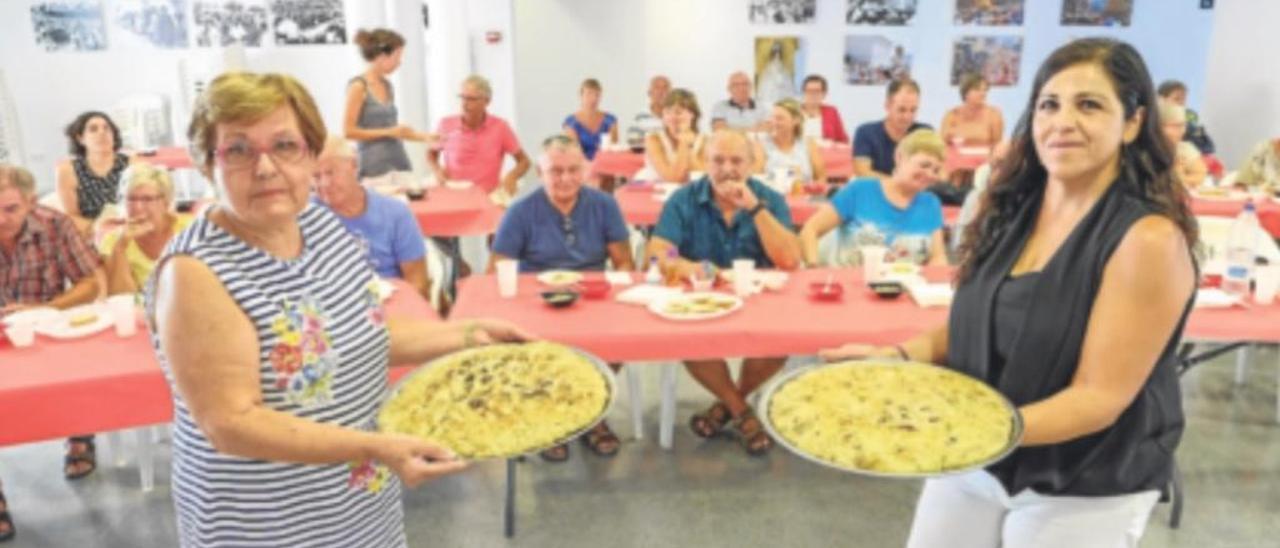 La alcaldesa, Raquel Asencio, a la derecha, mostrando las gachamigas junto a la ponente.