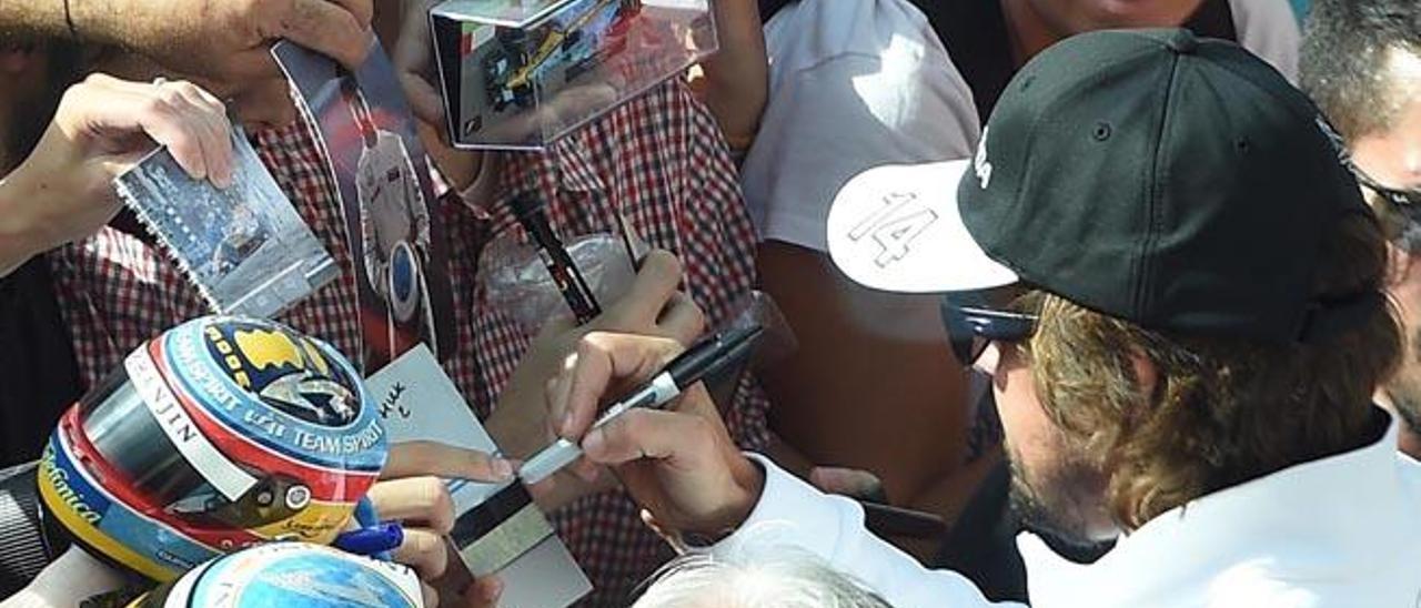 Fernando Alonso firma autógrafos en el circuito de Monza.