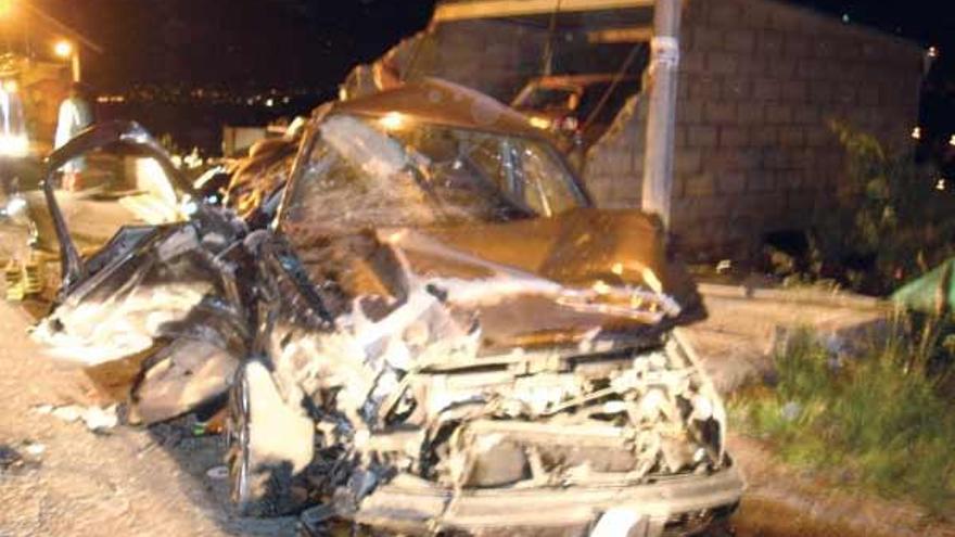 Dos jóvenes resultan heridos de madrugada al estrellarse su coche contra un garaje en Bueu