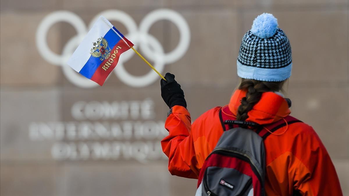 jcarmengol41199642 a woman holds a russian flag in front of the olympic rings l171205191031