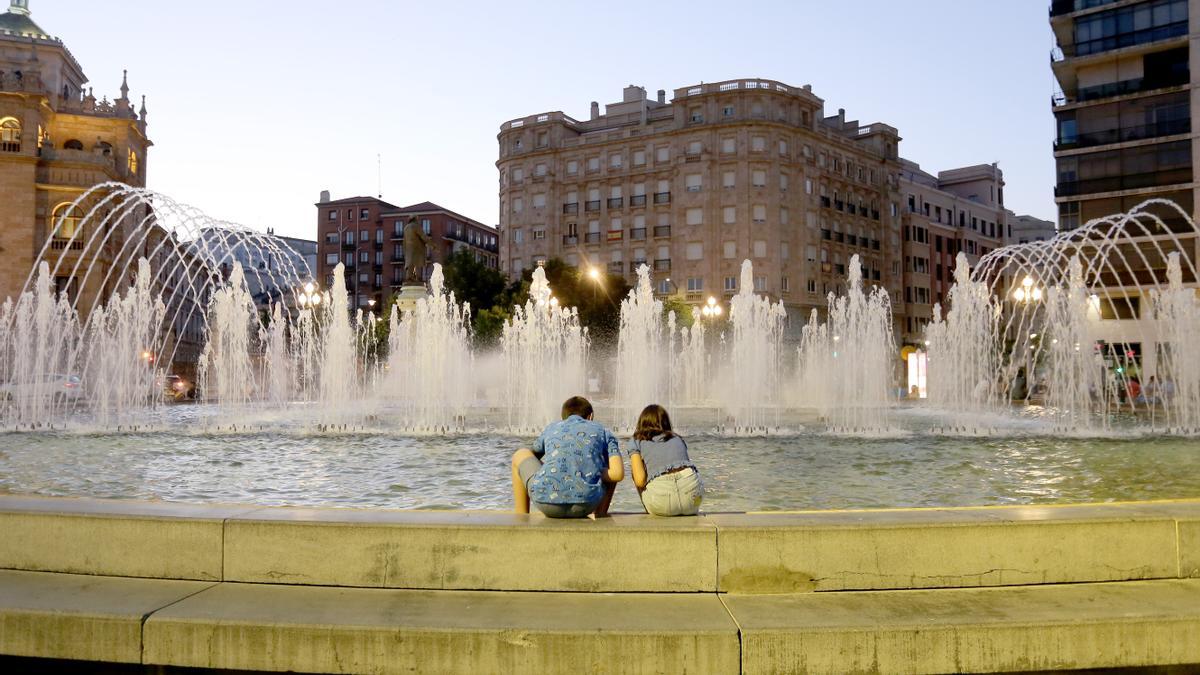 Dos niños se refrescan en la fuente de la plaza Zorilla de Valladolid.