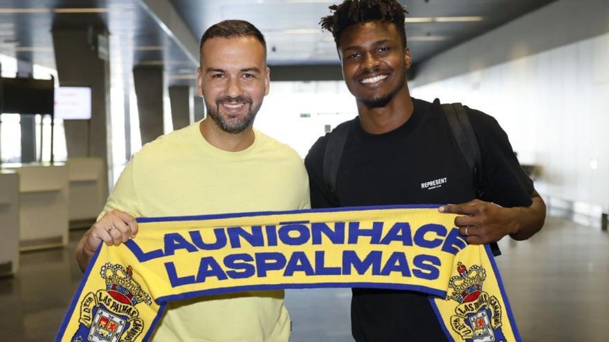 El delantero y flamante fichaje de la UD Las Palmas Sory Kaba posa con David Rodríguez ‘Deivid’, ayer, en el Aeropuerto de Gran Canaria con la bufanda de Las Palmas. | | LP/DLP