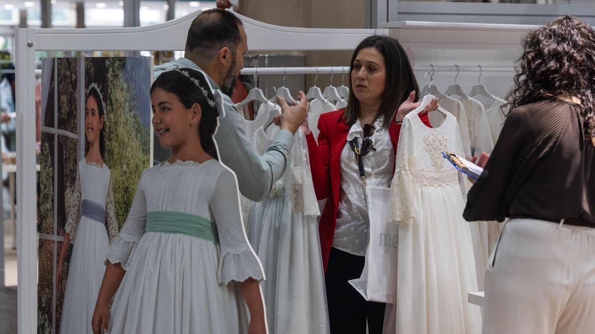Una pareja conversa durante la última feria de moda de comunión y ceremonia celebrada en València.