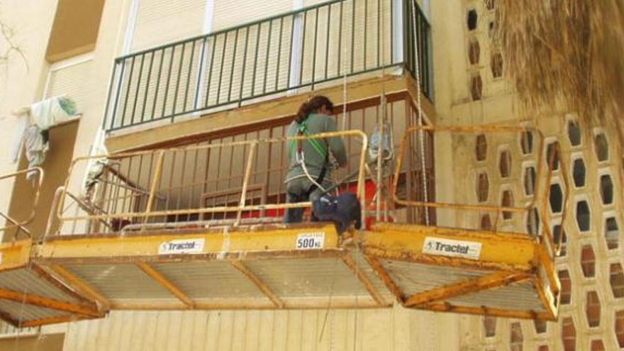 Un operario trabaja en la reparación de un edificio.