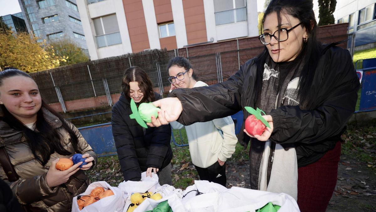 Cuatro alumnas reparten las bolsas reutilizables en el patio del colegio Baudilio Arce.