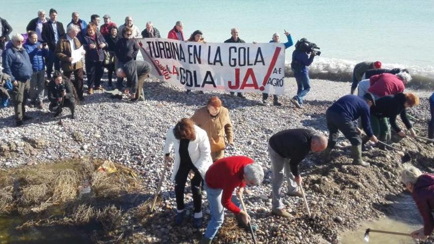 Asistentes a la protesta abrieron de nuevo a mano el tapón formado por las piedras para que la gola puedas desaguar.