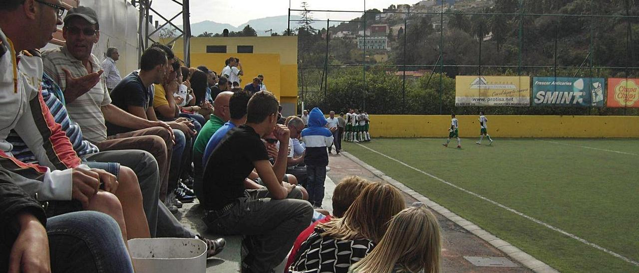 Espectadores en las gradas del campo municipal de fútbol de Los Olivos.