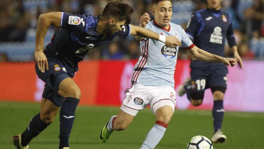 Un jugador del Espanyol intenta frenar a Emre Mor con un agarrón durante el partido de ayer en Balaídos. // Ricardo Grobas