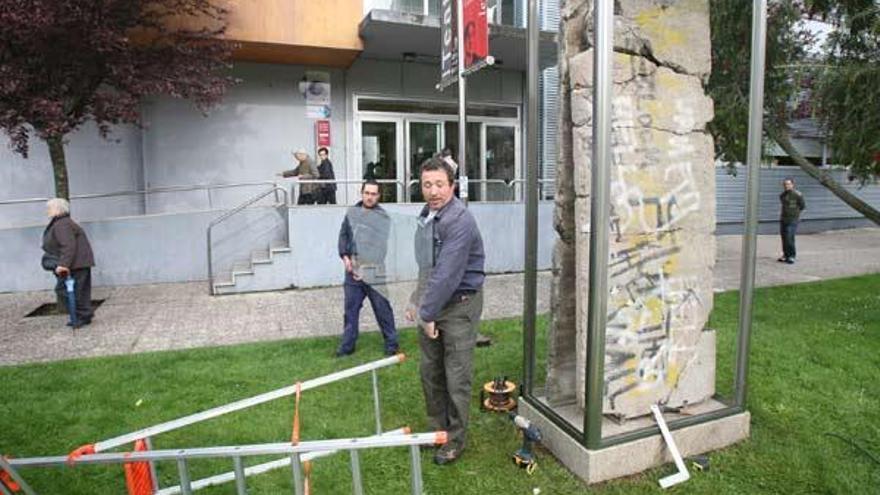 Unos operarios colocan los cristales que protegen los bloques del muro de Berlín, ayer.  // Jesús de Arcos