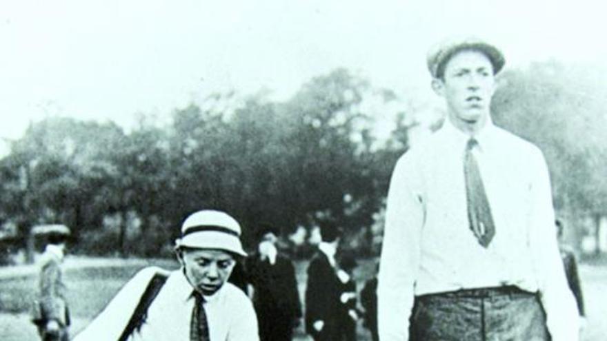 Francis Ouimet camina por el campo de golf junto a su caddie, el niño Eddie Lowery.