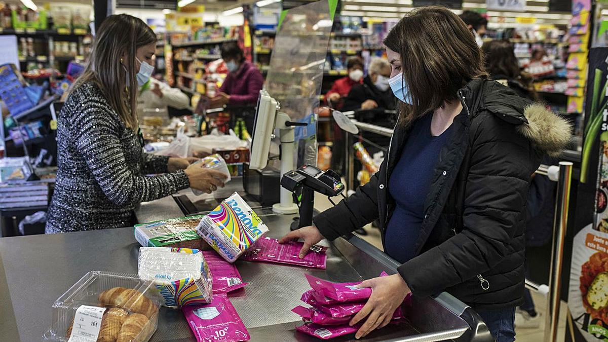 Una mujer compra mascarillas en uno de los supermercados de la localidad. | Emilio Fraile