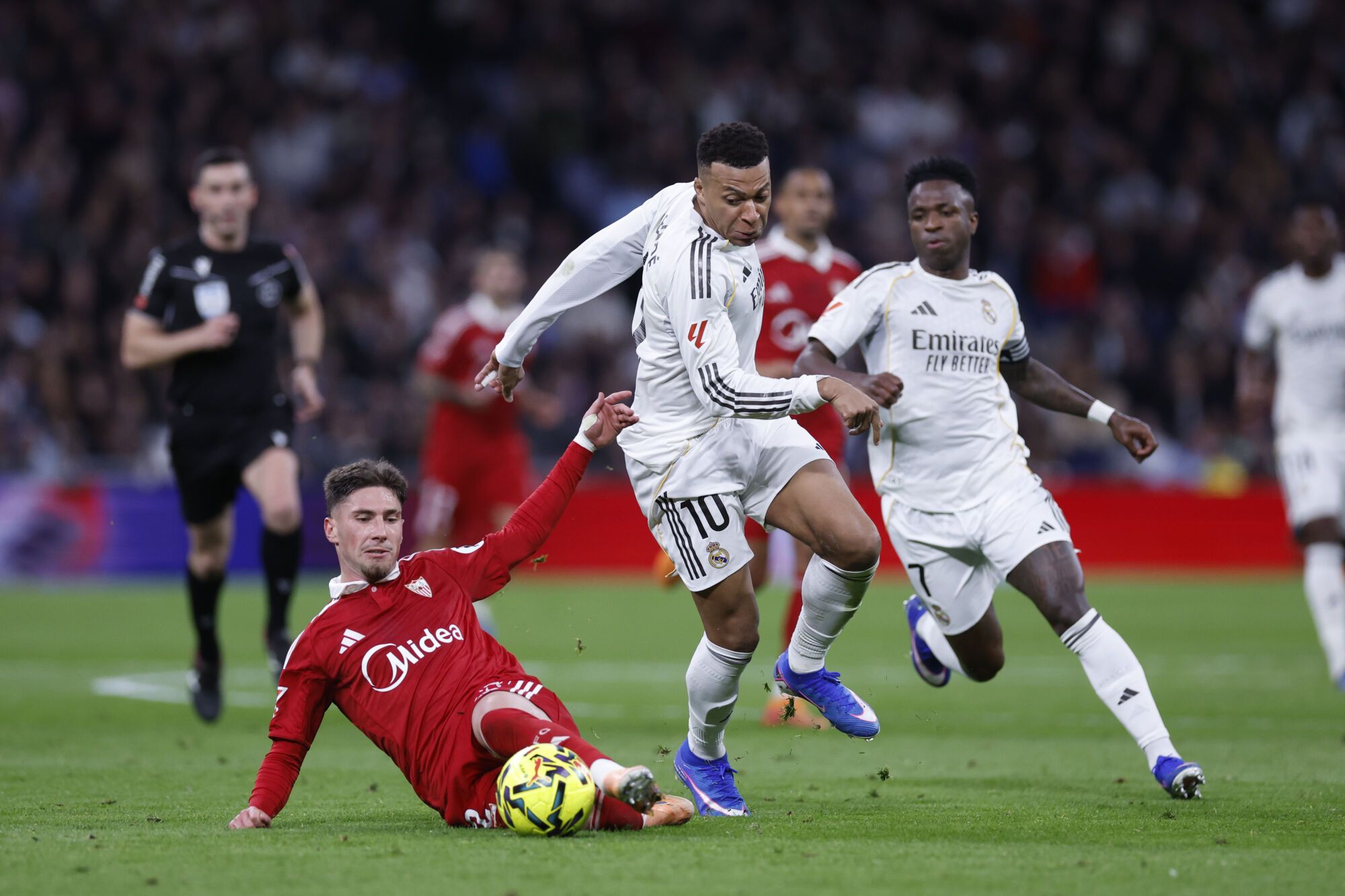 MADRID, 20/12/2025.- El defensa del Sevilla, José Ángel Carmona (i), disputa el balón ante el delantero francés del Real Madrid, Kylian Mbappé, durante el encuentro de la jornada 17 de LaLiga entre Real Madrid y Sevilla FC celebrado este sábado en el estadio Santiago Bernabéu, en Madrid. EFE / Javier Lizón.