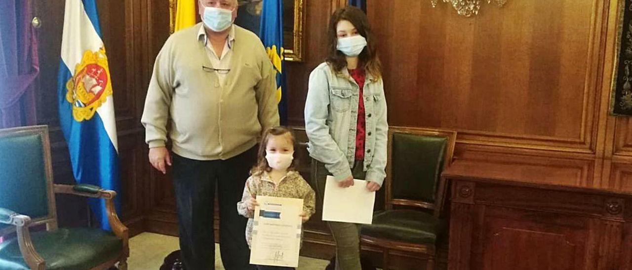 Carlos Guardado con sus nietas, Leire y Naiara, con el diploma firmado por la Alcaldesa.