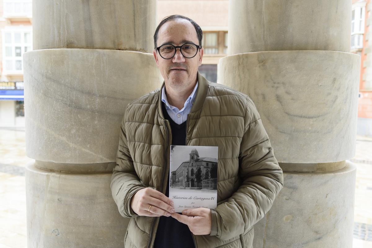 El autor Juan Ignacio Ferrández sostiene su libro, en una calle de Cartagena.