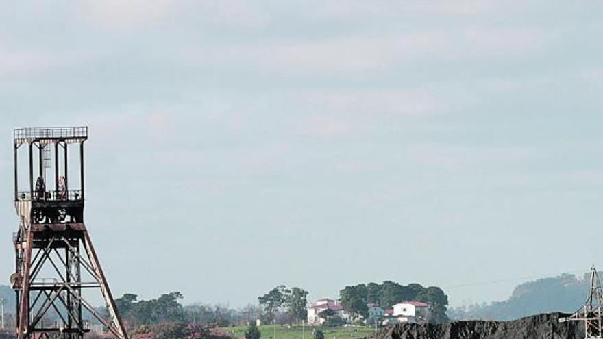 La escombrera norte de Mina La Camocha, tras varios edificios de la empresa en liquidación.