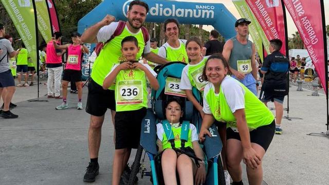El joven Nicolás, con su familia, en la carrera solidaria de Málaga en la que estrenó la silla adaptada. | L.O.