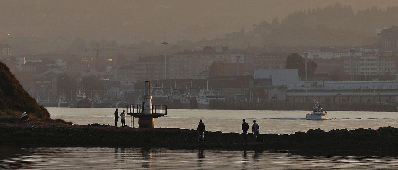 Un grupo de jóvenes, ayer, en el pedrero próximo a la Ensenada de Llodero, en la ría de Avilés. | Mara Villamuza