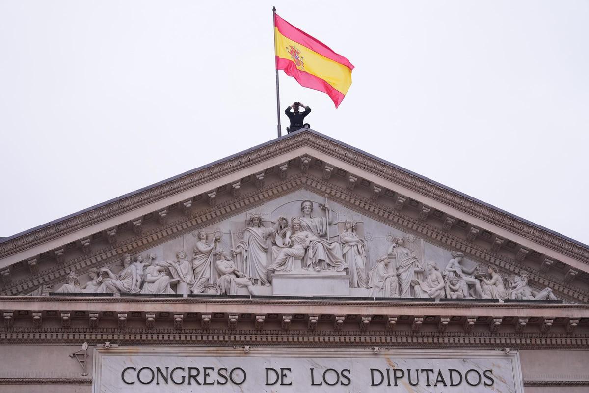 Un policía vigila desde la cubierta del Congreso de los Diputados