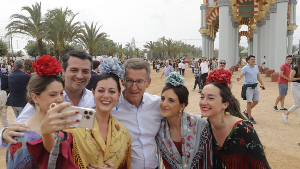 Bellido y Feijóo se toman un selfi junto a varias mujeres vestidas de flamenca.