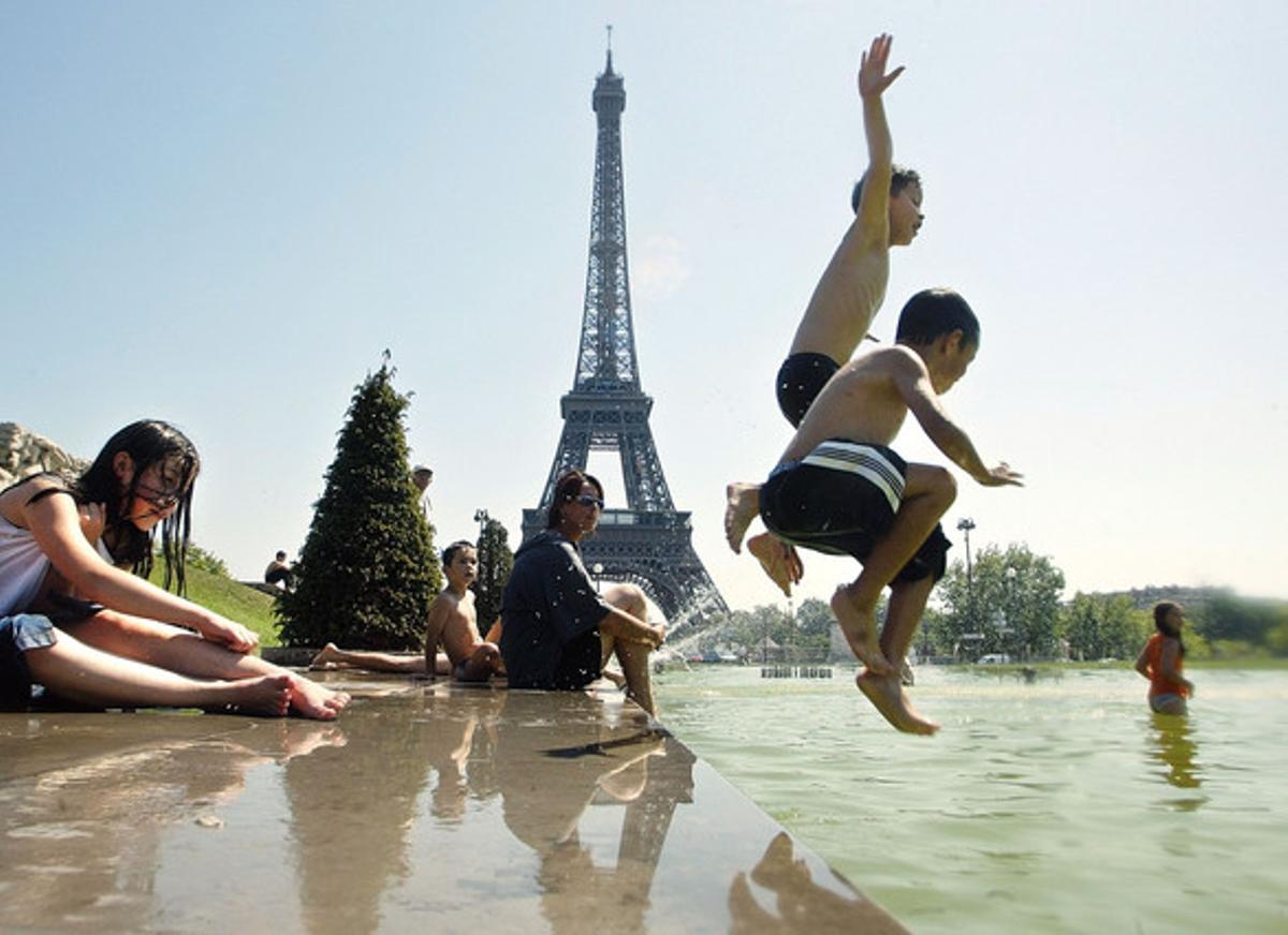 Niños saltando y bañándose en frente de la Torre Eiffel, en París.