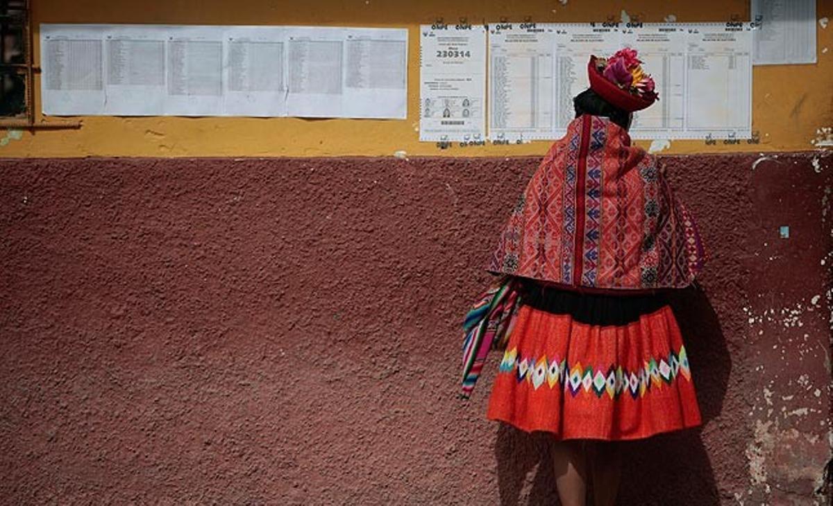 Una dona quítxua de la ciutat d’Ollantaytambo (Perú) busca aquest diumenge el número de la seva cabina de votació a la segona volta de les eleccions presidencials del país, que, segons els resultats provisionals de dilluns, hauria guanyat Ollanta Humala.