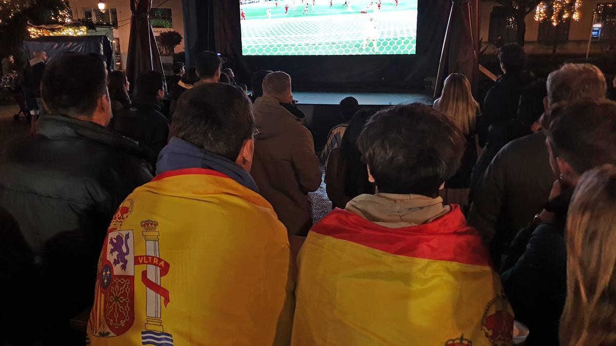 Varias personas en torno a la pantalla con el partido de fútbol de la selección española en la Alameda de Vigo.