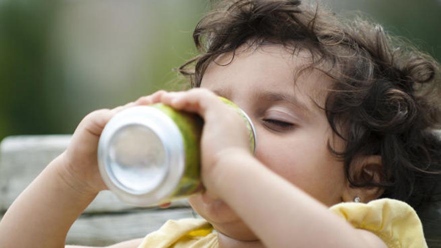 Una niña toma un refresco