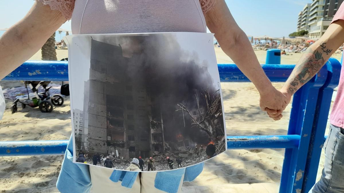 Una asistente enseña la foto de un bombardeo en una ciudad ucraniana.