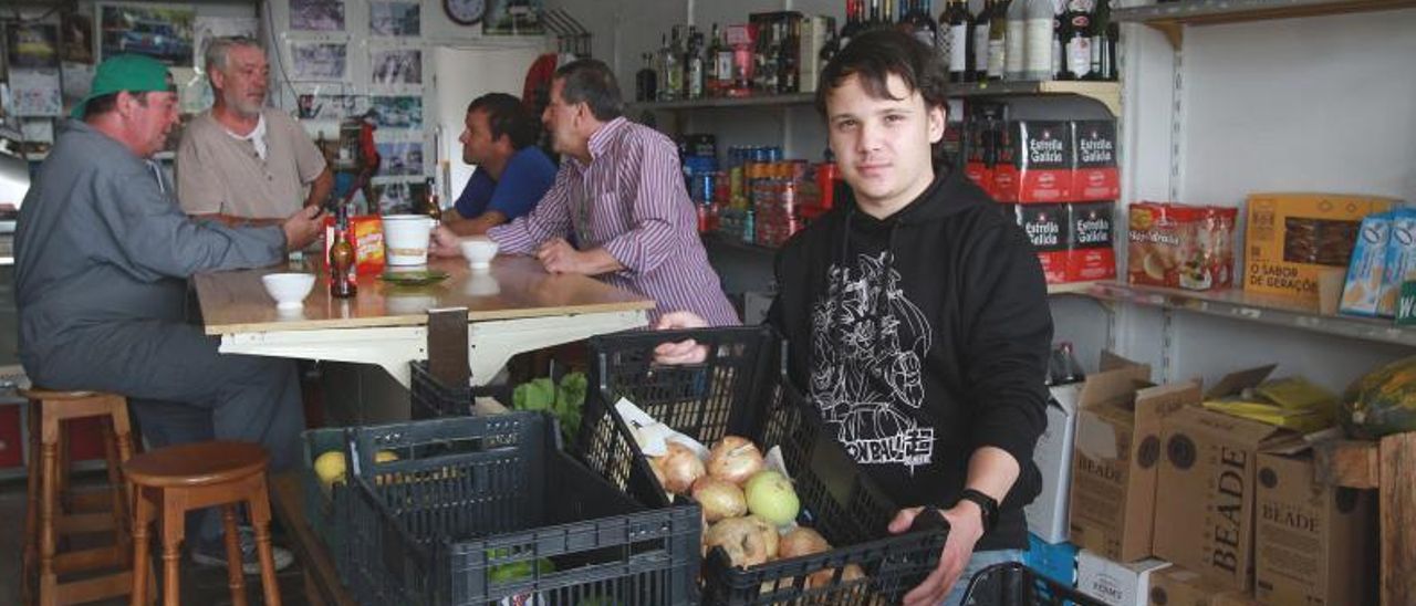 Gabriel Blanco con clientes en “La Tiendiña”, en el barrio de O Vinteún.   | // I. OSORIO