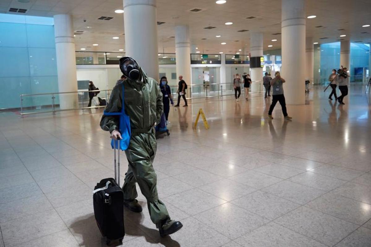 Un viajero con mono protector y máscara antigás en el aeropuerto de Barcelona, en mayo de 2020.