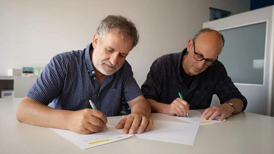 D&#039;esquerra a dreta: Toni Navarro i Enric Ramionet signant l&#039;acord de govern, ahir.