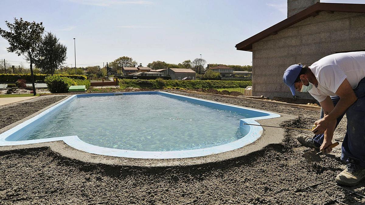 Un operario instala una piscina fija en un chalé de Lalín. |   // BERNABÉ/JAVIER LALÍN