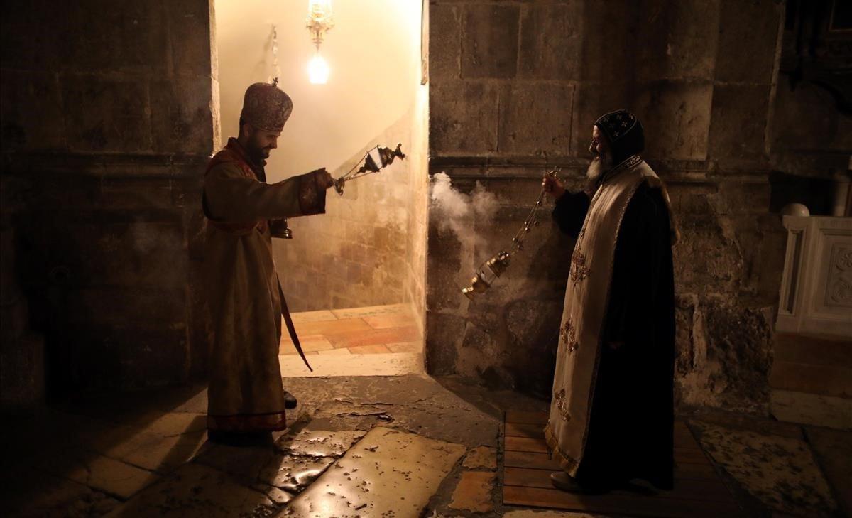 Miembros del clero cristiano ortodoxo dispersan incienso dentro de la Iglesia del Santo Sepulcro en la Ciudad Vieja de Jerusalén.