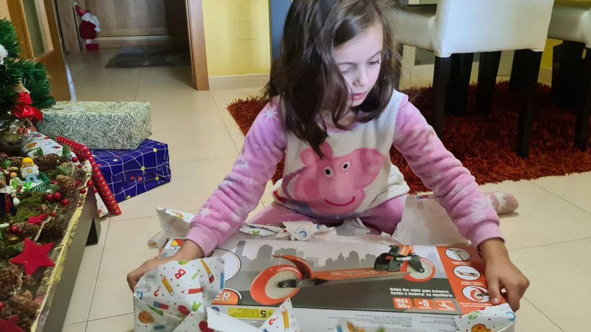 Una niña de A Bandeira abre un regalo por el día de Reyes.  | // BERNABÉ/JAVIER LALÍN