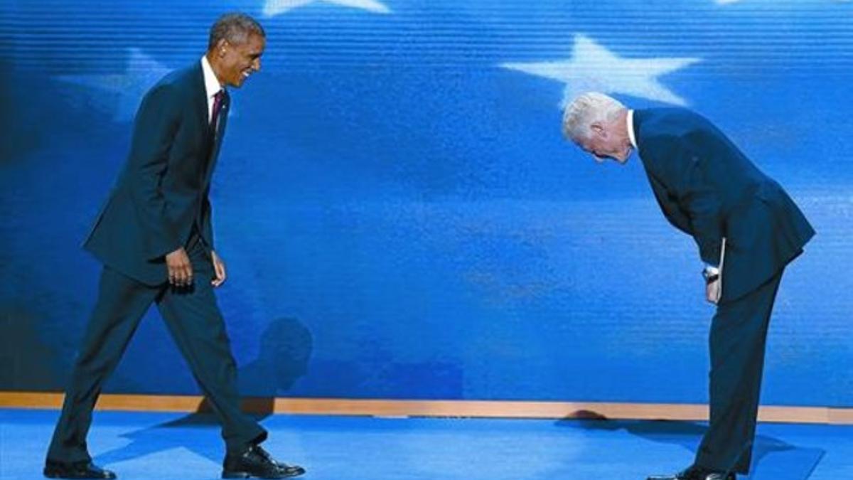 Clinton (derecha) se inclina ante Obama tras su discurso en la convención.