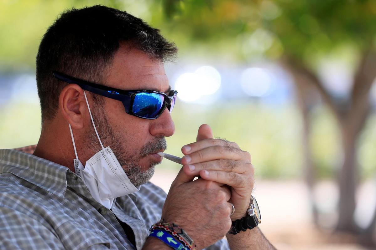 Un hombre se enciende un cigarro.