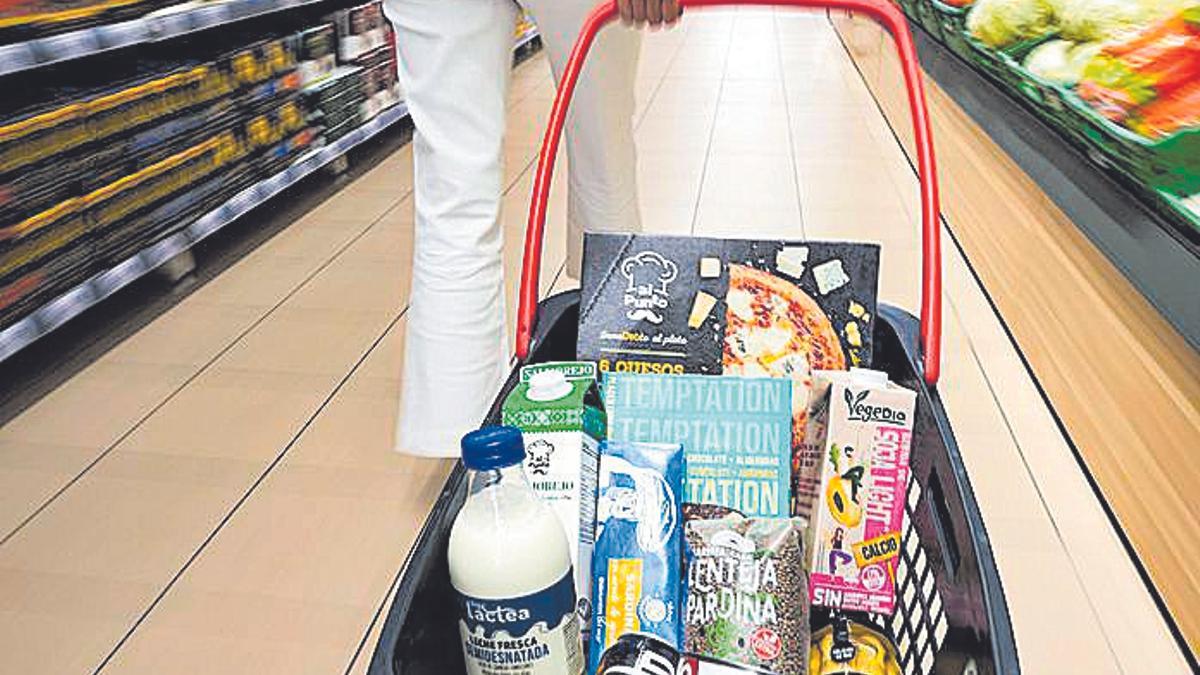 Una mujer con la cesta de la compra en un supermercado.